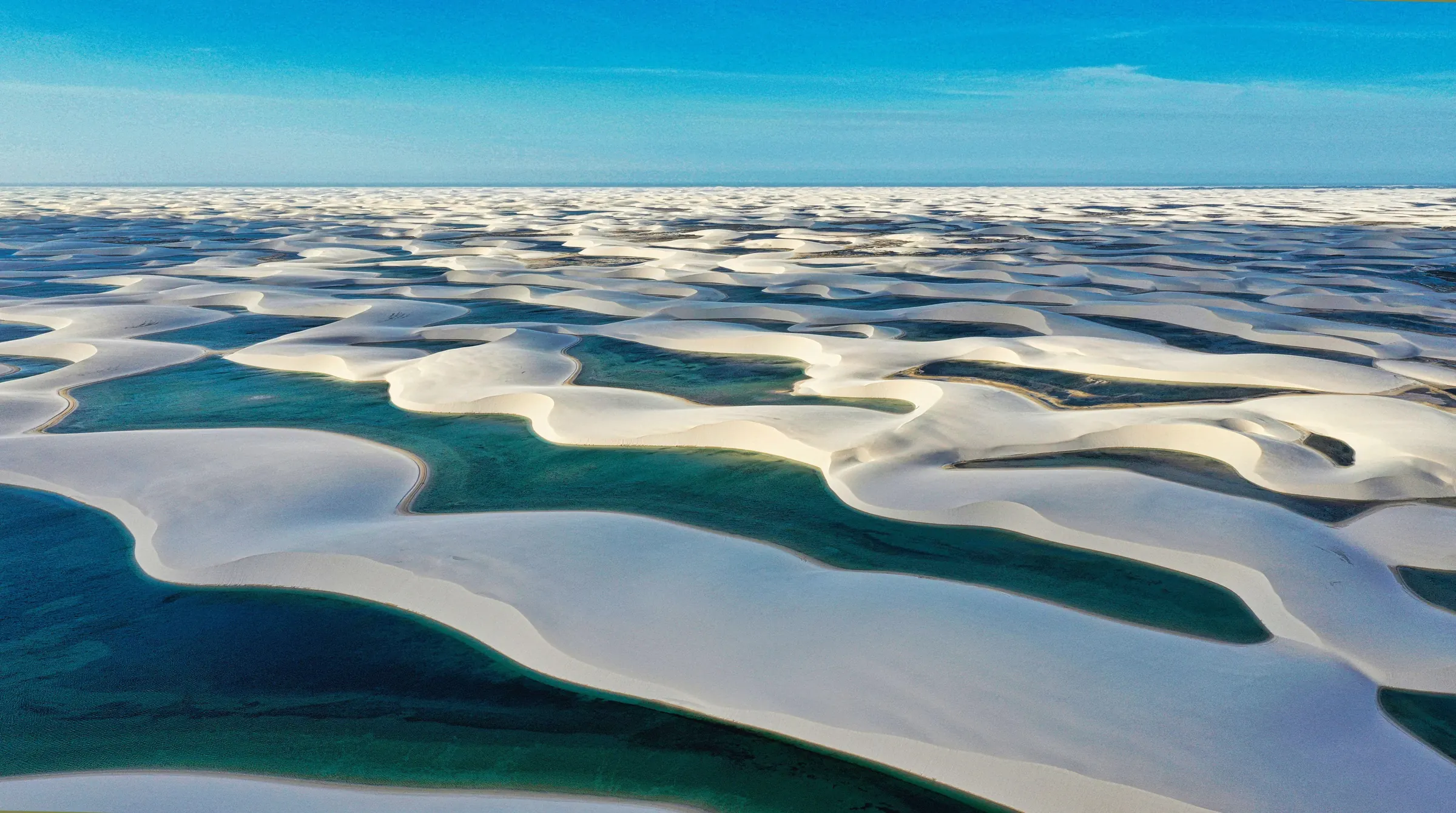Vista aérea das dunas brancas e lagoas azuis dos Lençóis Maranhenses